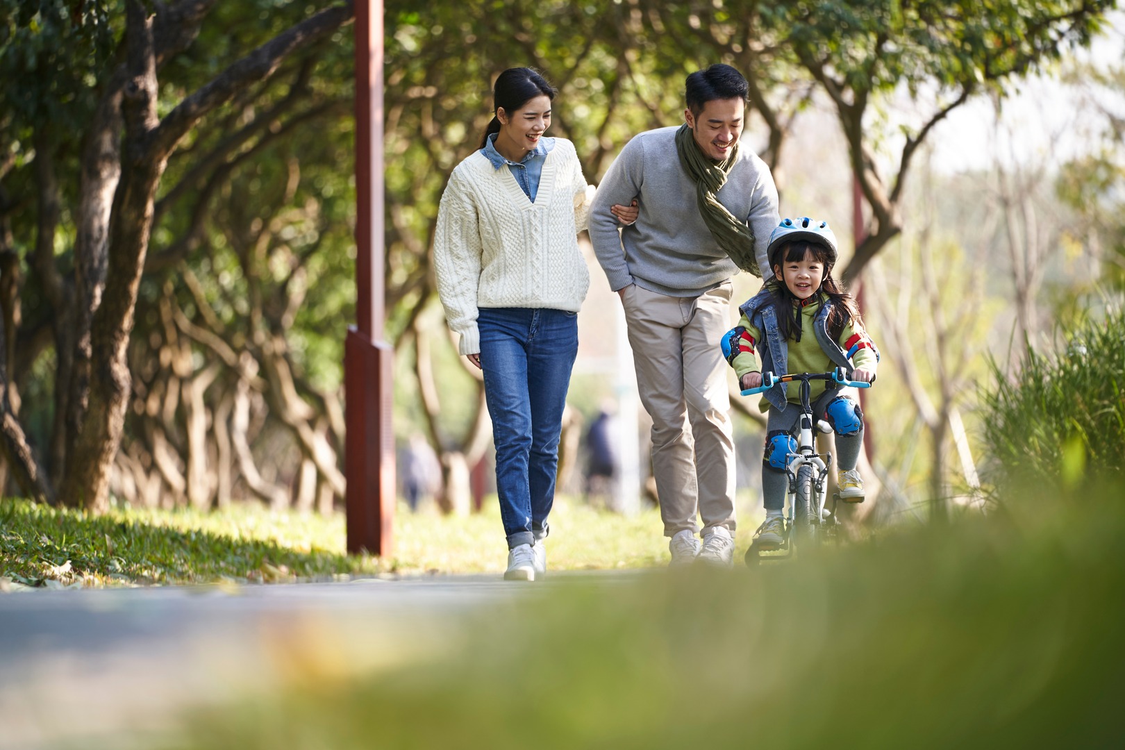 Young Asian Family Enjoying Outdoor Activity In City Park