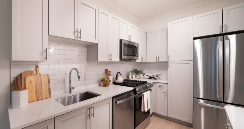 Kitchen with white stone counters and cabinets